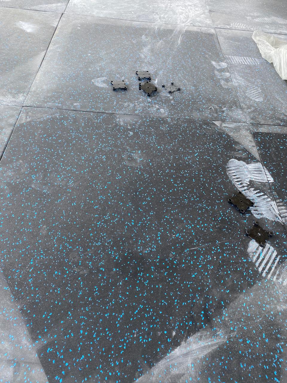 Installation of black and blue flecked heavy-duty rubber gym tiles in Nairobi