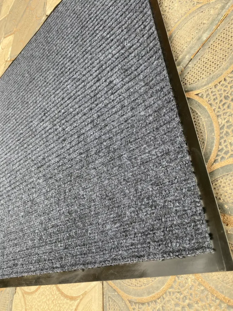 Grey ribbed carpet entrance mat with rubber backing, edge detail