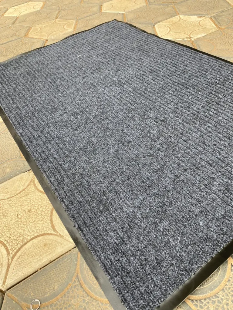 Ribbed carpet barrier mat laid on a tiled floor