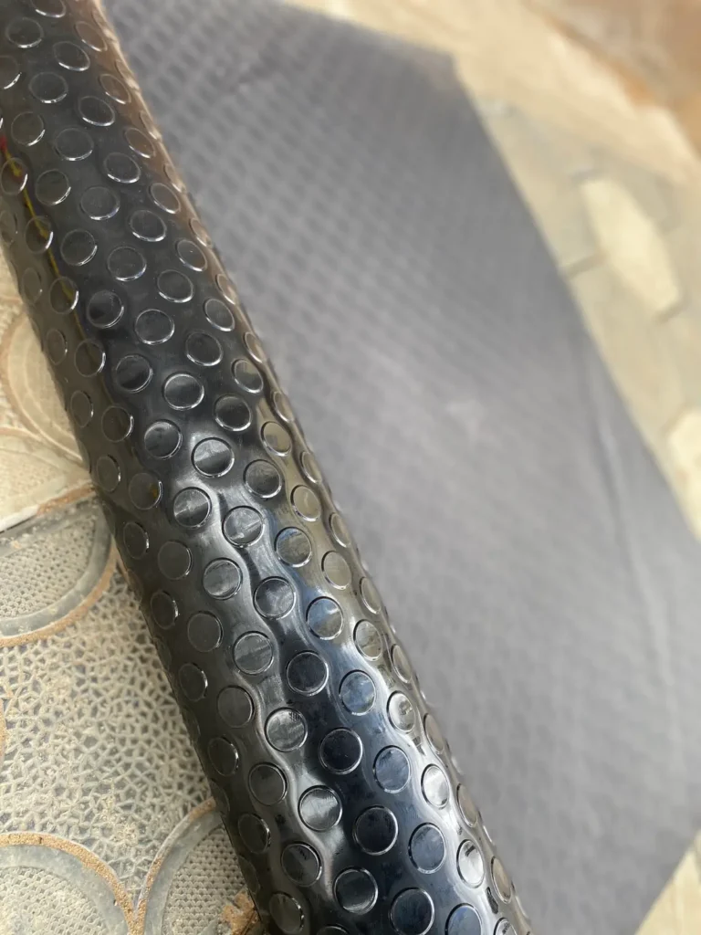 Rubber coin mat 4mm rolled out on a floor, raised coin pattern