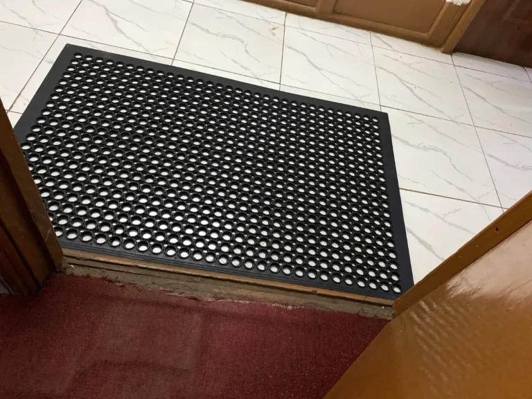 Black rubber ring entrance mat at a doorway with a red floor, Excel Deco Nairobi
