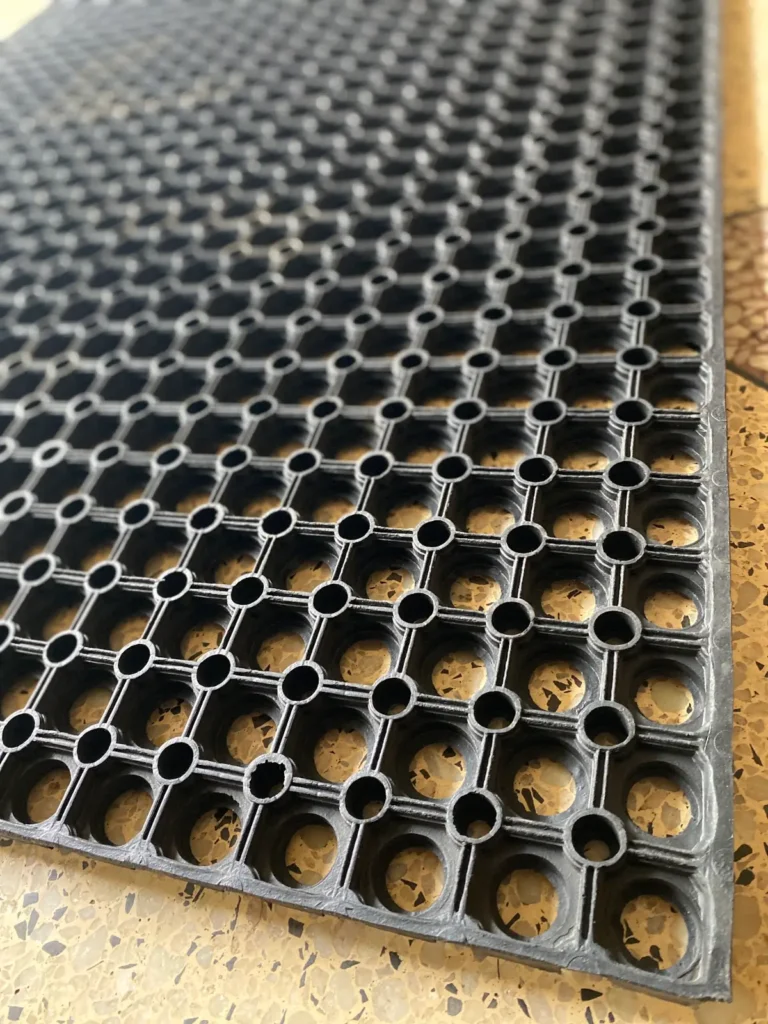 Close up of rubber ring mat holes that let water and mud drain through